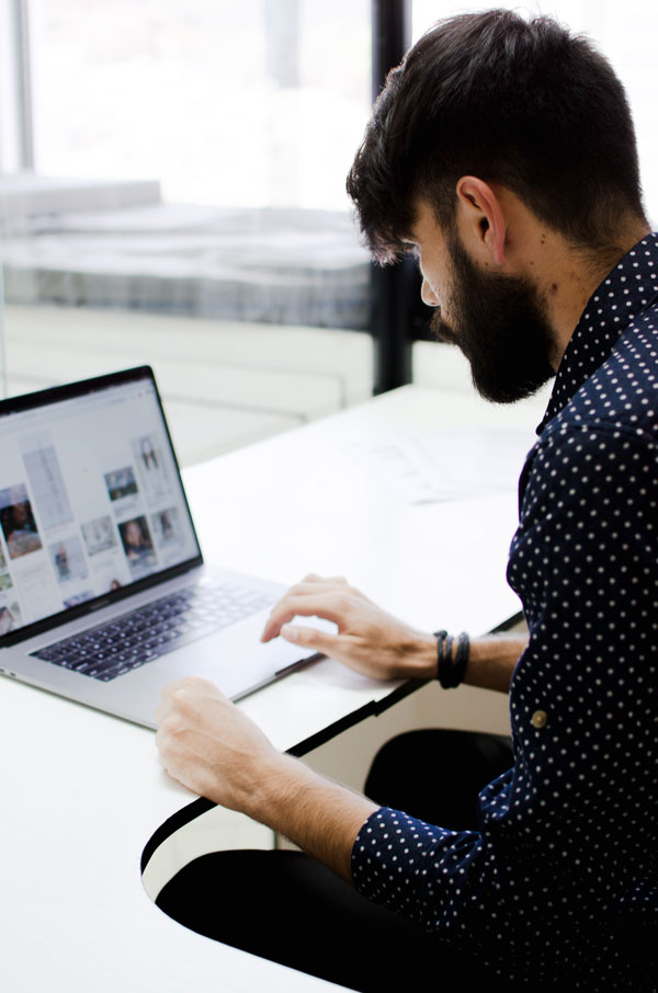 A man sits in front of a laptop for blog writing