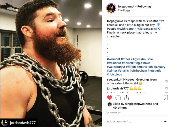 Man wears chains around his chest while working out in an Instagram Post from The Forge Gym.